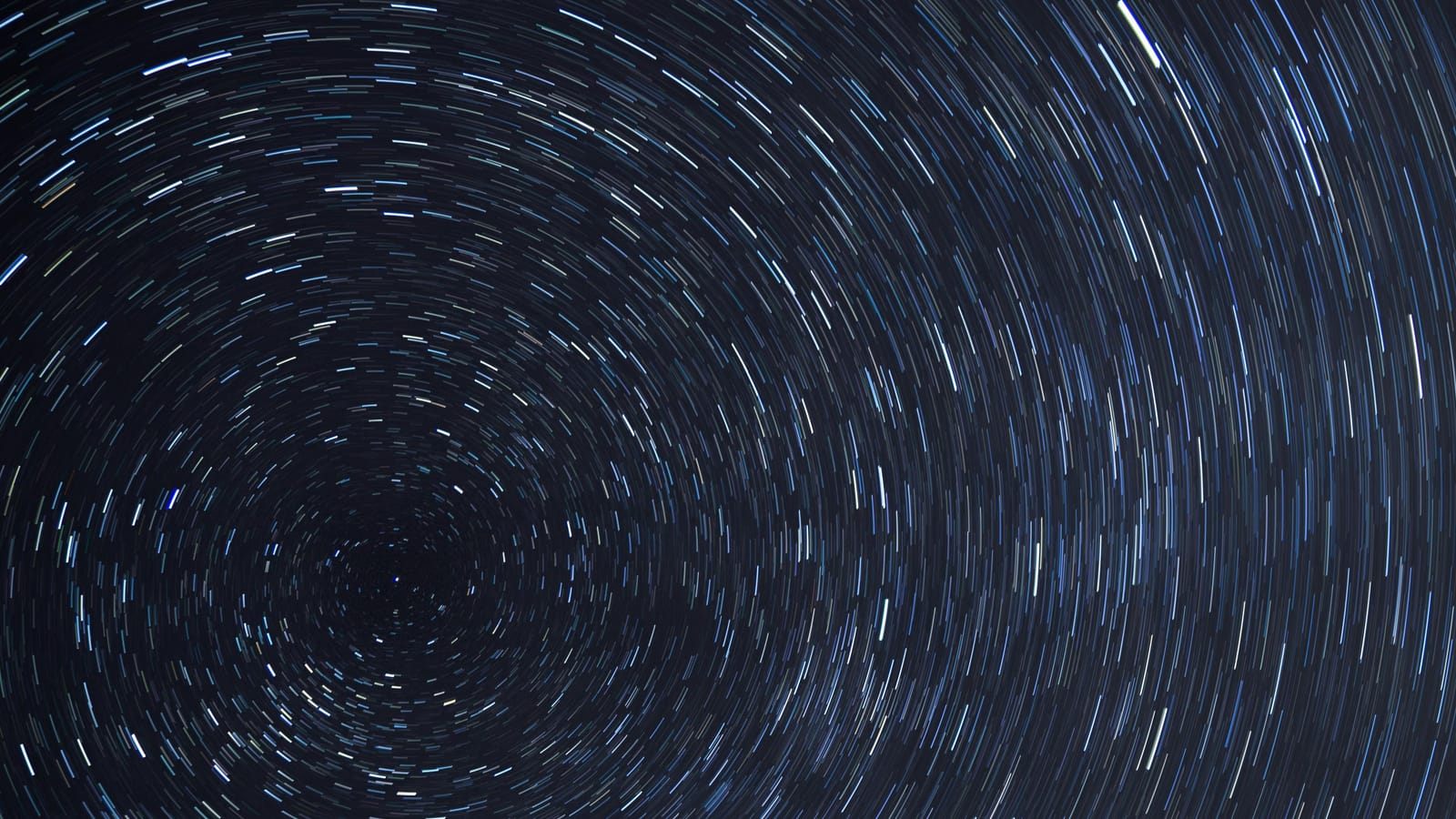 Dazzling star trails creating a spiral effect in the clear night sky.