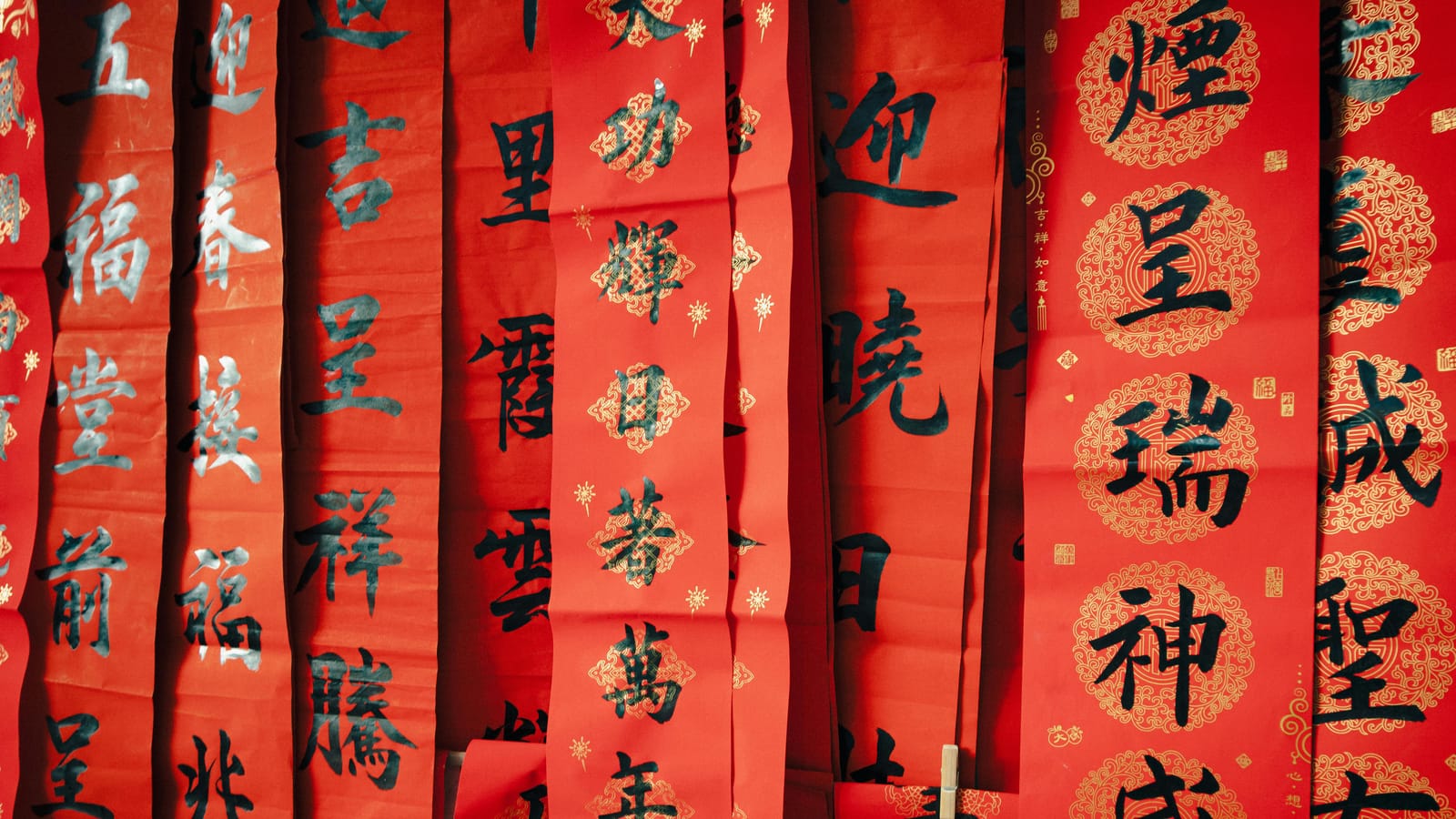 Decorative red Chinese scrolls celebrating Lunar New Year with traditional calligraphy and symbols of good fortune.