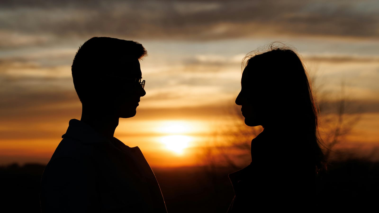 Silhouette of a couple in love at sunset, creating a romantic and intimate atmosphere.